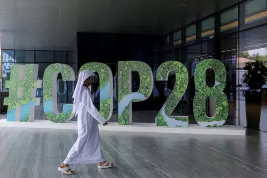  A person walks past a "#COP28" sign in Abu Dhabi, United Arab Emirates on October 1, 2023.