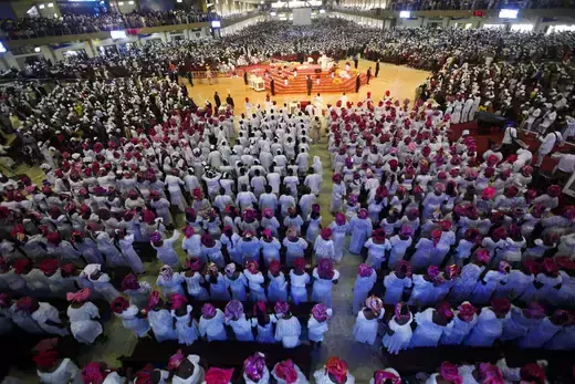 Hundreds of worshippers, dressed in traditional attire, attend a church service.
