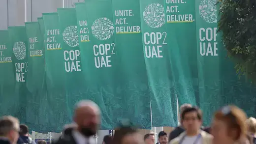 Participants walk by banners as they attend day four of the UNFCCC COP28 Climate Conference at Expo City Dubai.