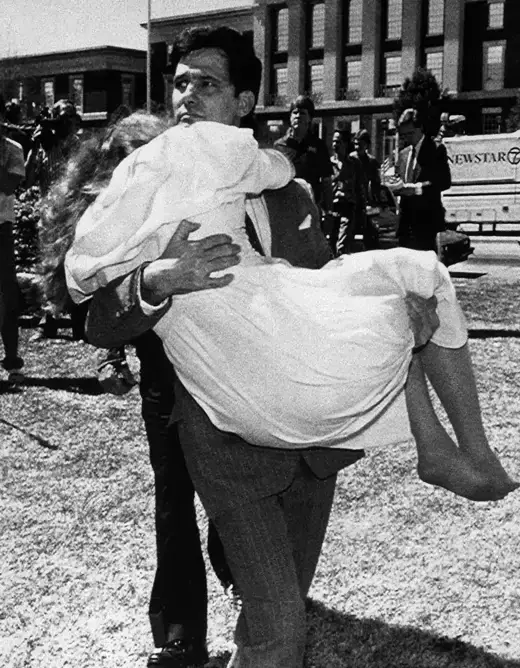 Louis Ray Beam Jr. carries his wife, Sheila, who had fainted, away from the federal courthouse in Fort Smith, Arkansas. after he and twelve other white supremacists are acquitted on sedition charges.