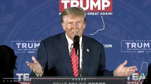 Trump as viewed speaking behind a microphone.
