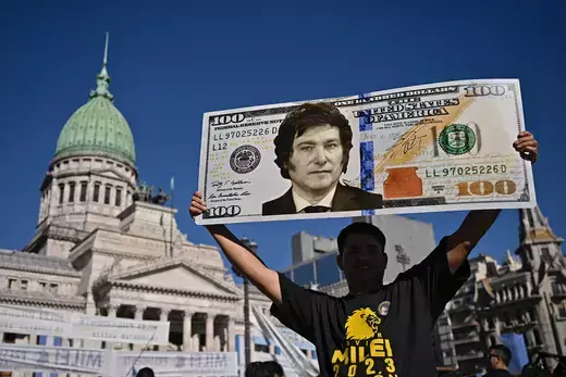 A supporter holds up a $100 bill sign of then President-Elect Javier Milei in December 2023.