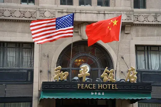 China's five-star red flag and the U.S. flag hang above the entrance of the Peace Hotel along the Nanjing Road Pedestrian Street in Shanghai, China, April 25, 2024. It is reported that US Secretary of State Antony Blinken arrived in Shanghai on the afternoon of the 24th, and Antony Blinken stayed at the Peace Hotel in Shanghai.