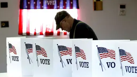 An American voter casts a ballot at an election booth. 