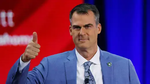 Oklahoma Governor Kevin Stitt gestures a thumbs up onstage at the Conservative Political Action Conference (CPAC) in Dallas, Texas.