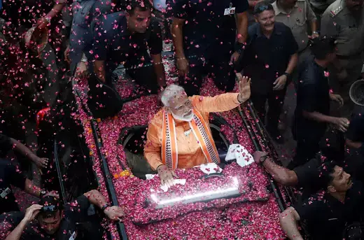 India's Prime Minister Narendra Modi waves towards his supporters during a roadshow in Varanasi, India.