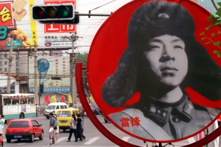 A portrait of Chinese national folk-hero, Lei Feng looks out over a busy intersection in a central Beijing shopping district in June of 1998.