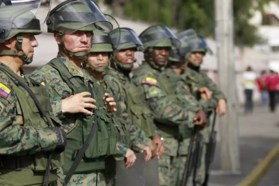 Soldiers stand guard outside Eufrasia high school in Quito (Guillermo Granja/Courtesy Reuters).
