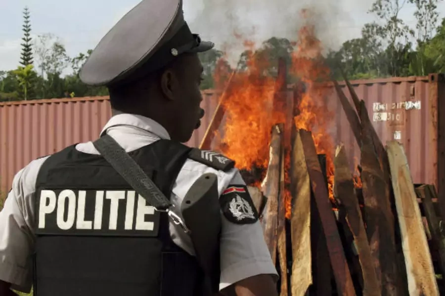 A policeman watches as confiscated cocaine and marijuana are incinerated in Paramaribo, Suriname on April 19, 2011. Suriname is a transit point for drugs headed to Europe, Africa, and the United States (Ranu Abhelakh/Courtesy Reuters).