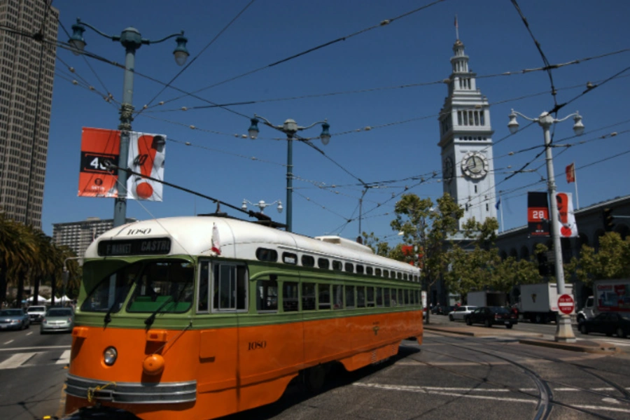 A brightly colored streetcar moves past the Ferry Building in San Francisco in May, 2012 (Robert Galbraith/Courtesy Reuters).