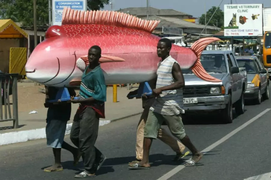 Carpenters carry a coffin shaped in the form of a fish over the main road in Teshie, a suburb of the Ghanaian capital of Accra...orate, brightly colored coffins have become an art form. Picture taken on January 22, 2004 (Wolfgang Rattay/Courtesy Reuters).