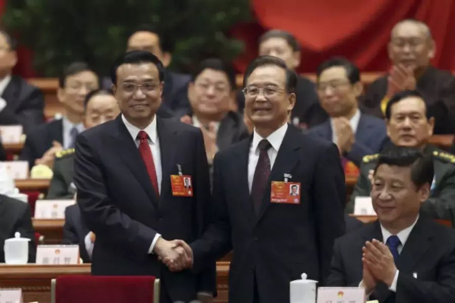 China's newly elected Premier Li Keqiang (L) shakes hands with Wen Jiabao as China's President Xi Jinping and other delegates ...enary meeting of the first session of the 12th National People's Congress (NPC) in Beijing, March 15, 2013 (Courtesy Reuters).