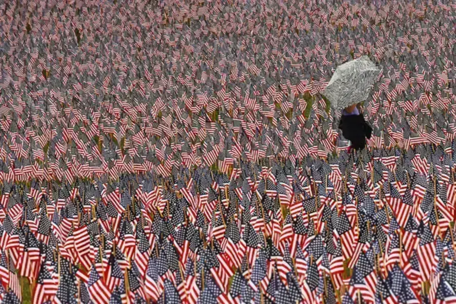 A pedestrian walks through a Memorial Day display of American flags on the Boston Common (Brian Snyder/Courtesy Reuters).