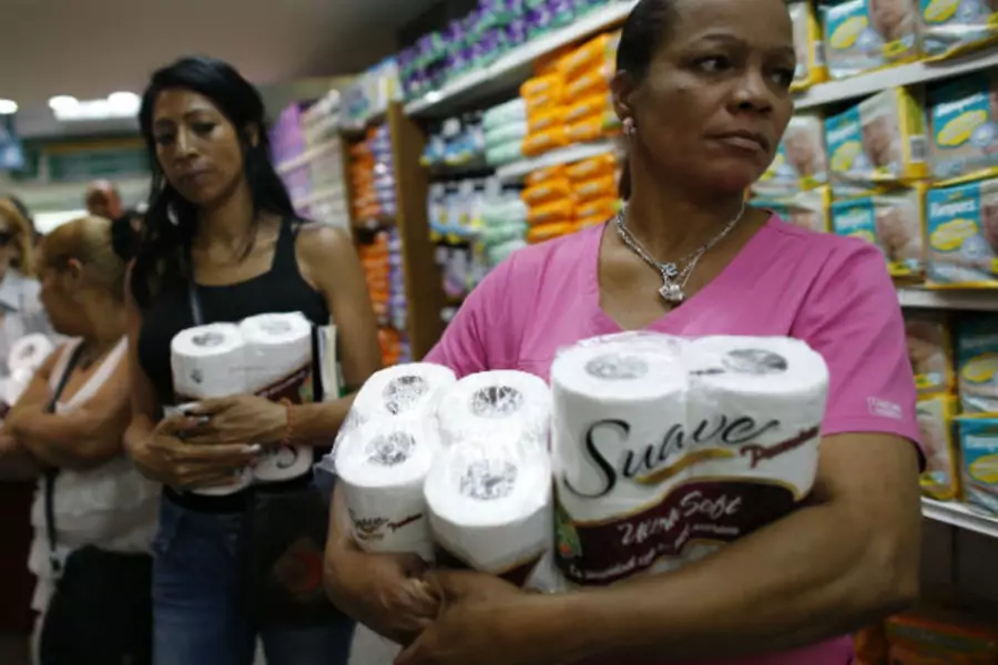 Women wait in line as they buy toilet paper at a supermarket in Caracas May 17, 2013 (Jorge Silva/Courtesy Reuters).