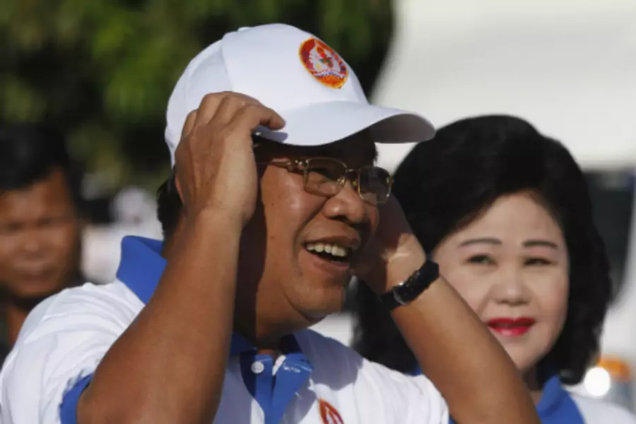 Cambodia's Prime Minister Hun Sen and his wife Bun Rany (R) arrive at an election campaign area in Phnom Penh on June 27, 2013. (Pring Samrang/Courtesy Reuters)