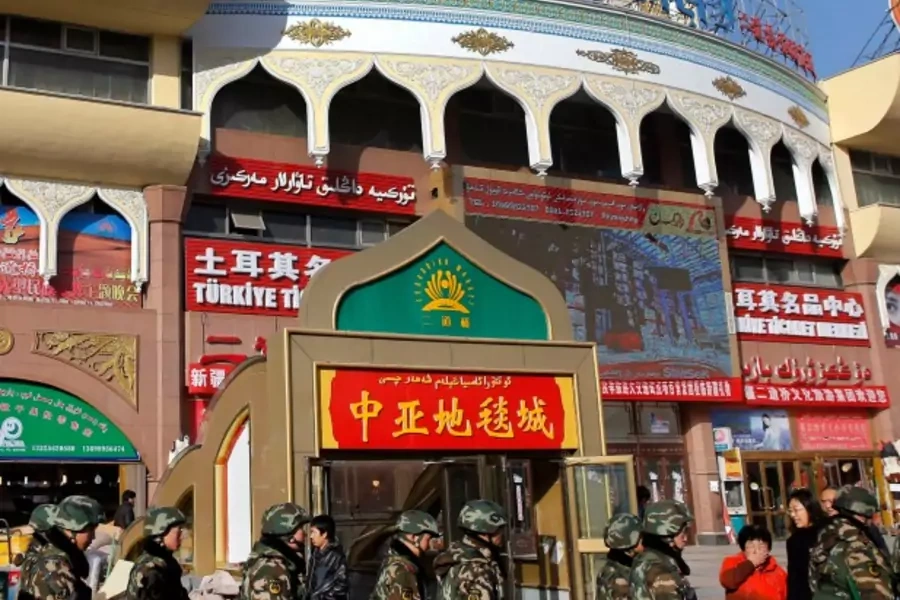 Paramilitary policemen walk past Erdaoqiao Grand Bazaar in Urumqi, Xinjiang Uighur autonomous region on November 17, 2013 (Rooney Chen).