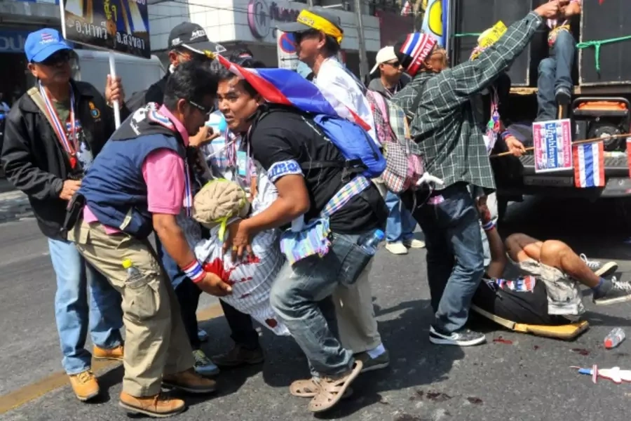 Anti-government protesters help a fellow protester injured in a grenade attack during a rally in Bangkok on January 17, 2014. (Stringer/Courtesy Reuters)