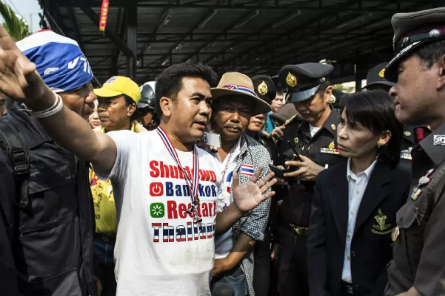 An anti-government protester (C) negotiates with a local official and police officers regarding the closing of a polling stati...blocked its entrance during advance voting for a general election in Bangkok on January 26, 2014. (Nir Elias/Courtesy Reuters)
