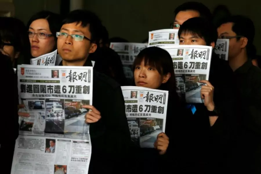 Journalists and editors from Ming Pao hold up front pages of their newspaper during a protest against violence in Hong Kong February 27, 2014, after Wednesday's attack on their former chief editor Kevin Lau. (Bobby Yip/Courtesy Reuters)