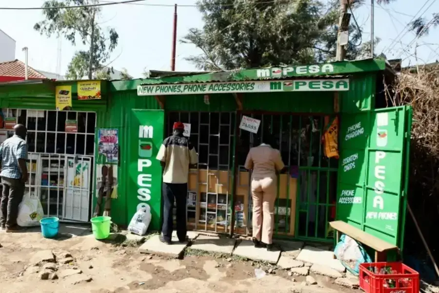 Customers are seen at mobile money transfers kiosks, known as M-Pesa agents, near Nairobi, Kenya, July 2013 (Courtesy Reuters/Thomas Mukoya).