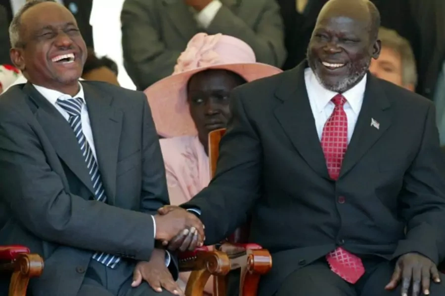 Sudan's Ali Osman Mohamed Taha and Sudan People's Liberation Movement leader John Garang laugh before the signing of the Comprehensive Peace Agreement in Kenya's capital Nairobi, January 9, 2005. (Courtesy REUTERS/Antony Njuguna)