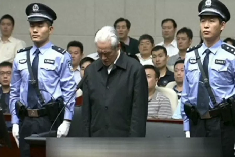 Zhou Yongkang, China's former domestic security chief, stands between his police escorts as he listens to his sentence in a co...'s Court ruled in its first instance. Zhou pleaded guilty and will not appeal. REUTERS/China Central Television via REUTERS TV