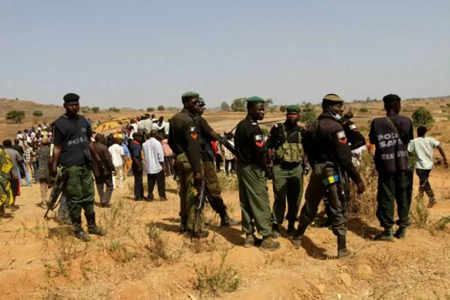 Police stand guard during a mass burial of victims of religious attacks in the Dogo Nahawa village, about 15 km (9 miles) to t... attacks on outlying communities in which several hundred people were feared to have been killed (Reuters/ Akintunde Akinleye)