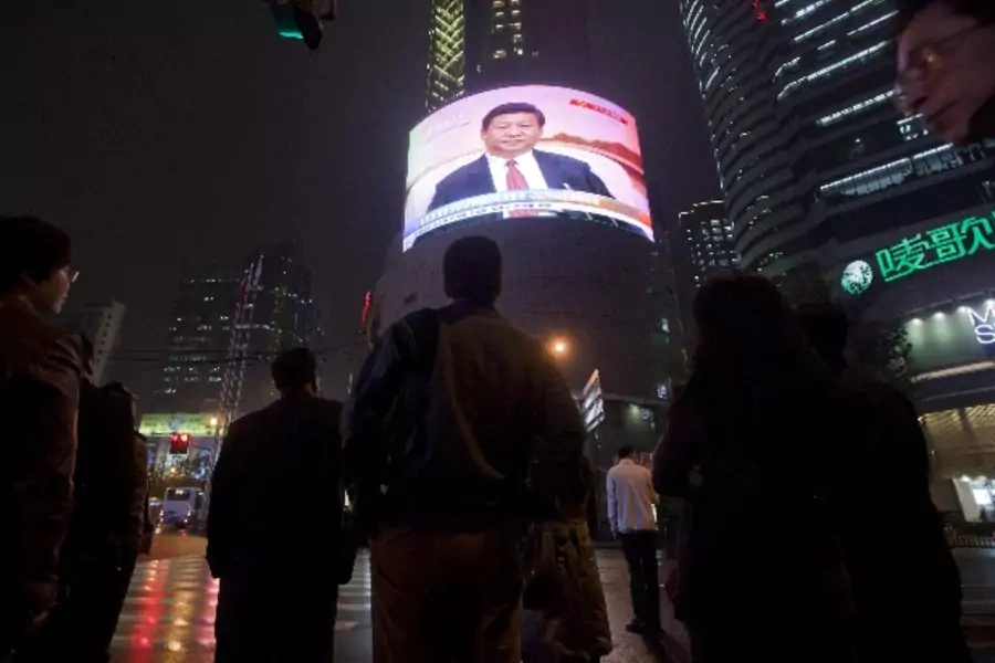 People watch a TV showing of a huge screen shows a news broadcast of China's Vice President Xi Jinping at the 18th Communist Party Congress at a crossroads in Shanghai November 8, 2012. REUTERS/Aly Song (CHINA - Tags: POLITICS)