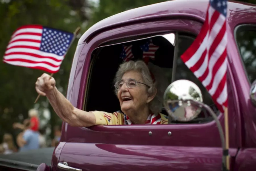 A woman waves an American flag as she rides in an antique pickup truck through Barnstable Village on Cape Cod, during the annual Fourth of July Parade celebrating the country's Independence Day, in Barnstable, Massachusetts (Mike Segar/Reuters).