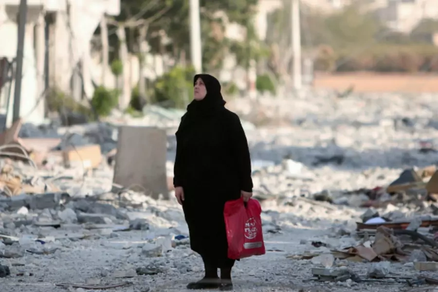 A woman stands along a damaged street in Manbij, Aleppo Governorate, Syria (Rodi Said/Reuters).