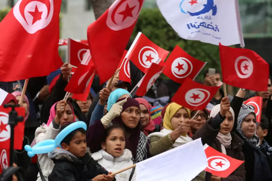 People wave national flags during celebrations marking the sixth anniversary of Tunisia's 2011 revolution in Habib Bourguiba Avenue in Tunis, Tunisia (Zoubeir Souissi/Reuters).