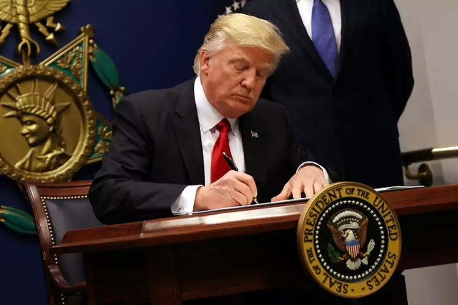 President Donald Trump signs an executive order imposing tighter vetting on travelers entering the United States. (Photo: Reuters/Carlos Barria)
