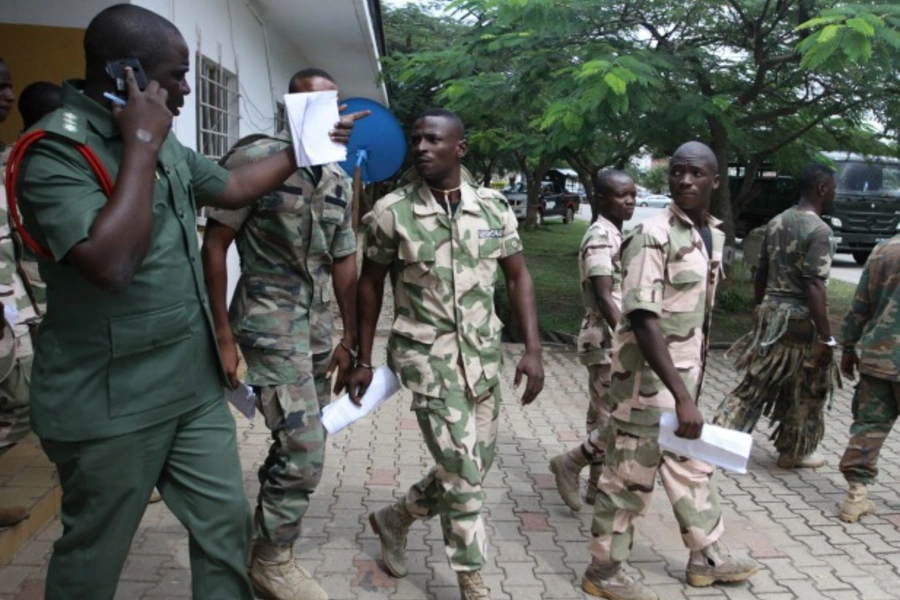 Nigerian soldiers, handcuffed in pairs, leave the court premises after the opening of the General court-martial in Abuja October 2, 2014. 