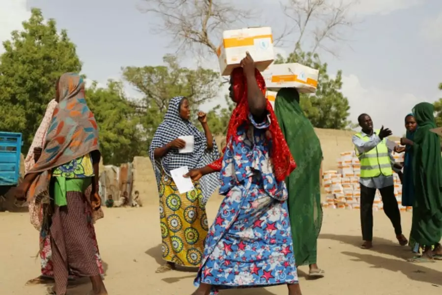 Women carry food supplement received from World Food Programme (WFP) at the Banki IDP camp, in Borno, Nigeria, April 26, 2017.