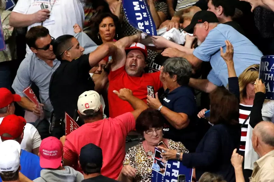 A protester is removed from a rally with U.S. President Donald Trump and supporters.