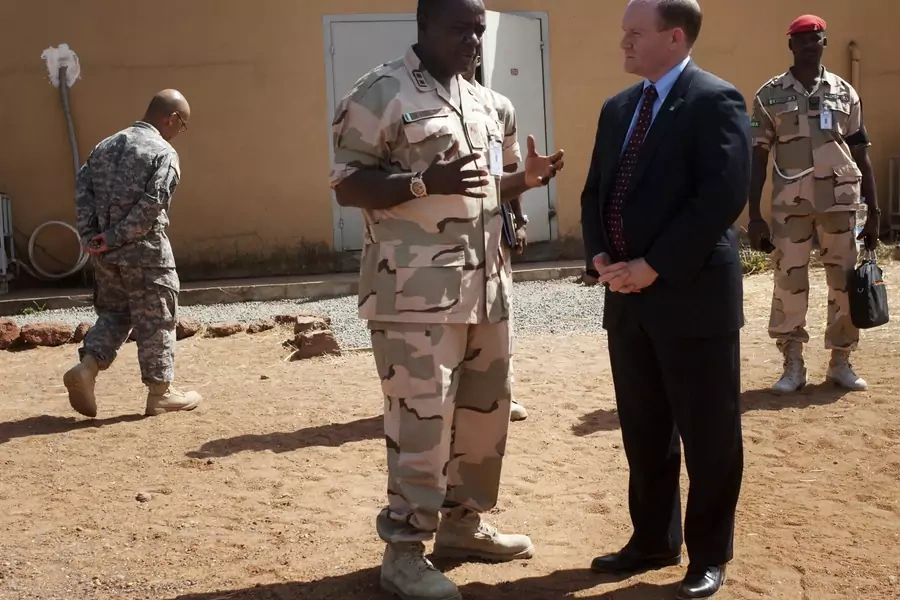 U.S. Senator Chris Coons (C) chats with Force Commander Major General Shehu Abdulkadir on a previous CODEL during President Obama's administration, in Bamako, Mali, February 18, 2013. 