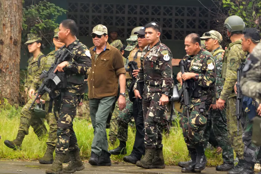 Philippine President Rodrigo Duterte walks with soldiers during his visit at Bangolo town in Marawi city, southern Philippines, on October 17, 2017.