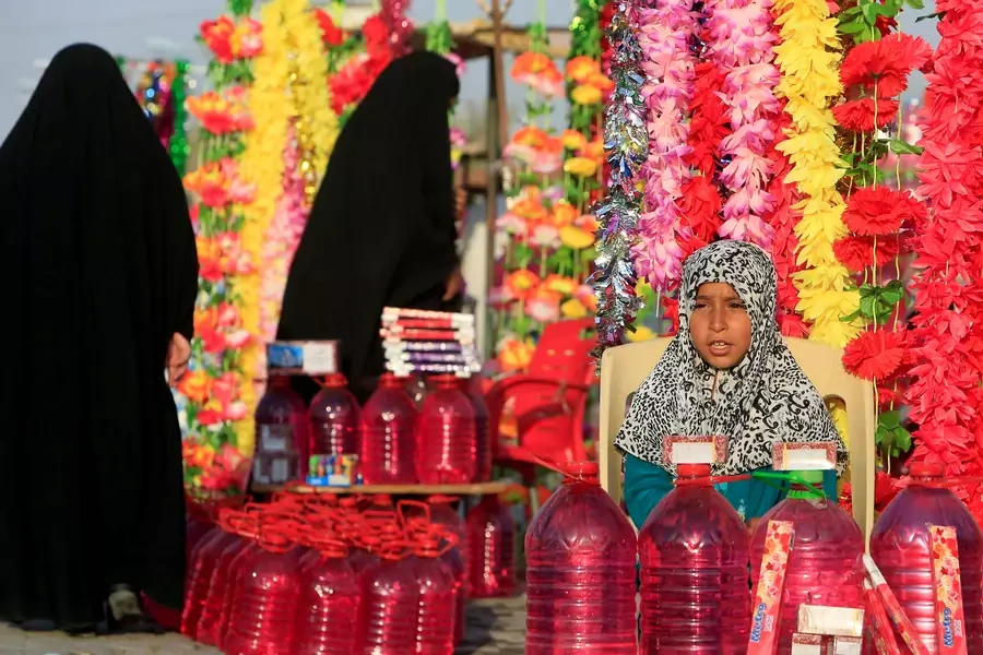 An adolescent girl sells water and flowers during the Muslim festival of Eid al-Adha in Najaf, Iraq September 3, 2017.