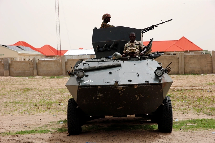 Soldiers stand guard on a armoured tank outside an internal displaced persons (IDP) camp during the official flag-off of food and relief materials distribution for the internal displaced persons in Nigerian city of Maiduguri, June 8, 2017.