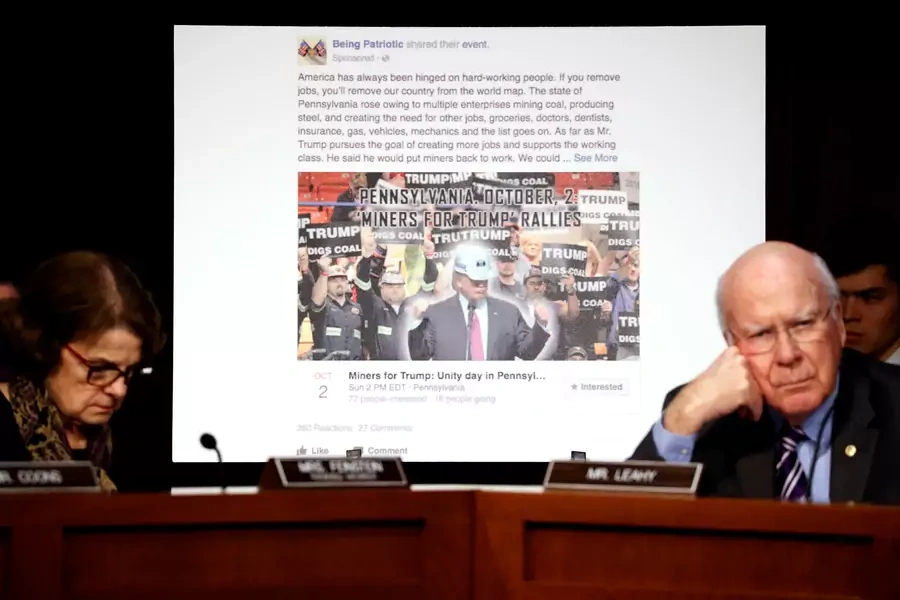 U.S. Senator Dianne Feinstein (D-CA) (L) and Senator Pat Leahy (D-VT) show a fake social media post for a non-existent "Miners for Trump" rally as representatives of Twitter, Facebook and Google 