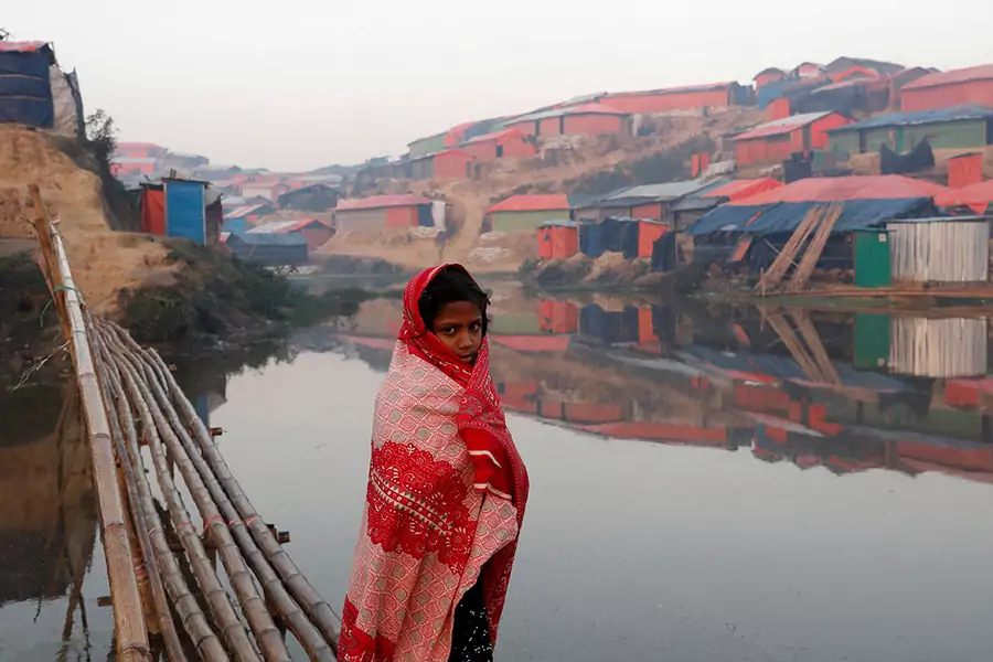 A Rohingya refugee girl walks next to a pond in the early morning at Balukhali refugee camp near Cox's Bazar, Bangladesh, on January 10, 2018.