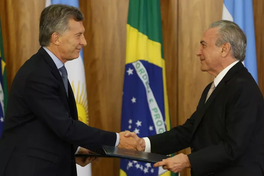 Argentine President Mauricio Macri (L) and his Brazilian counterpart Michel Temer exchange documents after a meeting to discuss closer trade cooperation at the Planalto Palace in Brasilia, Brazil February 7, 2017. 