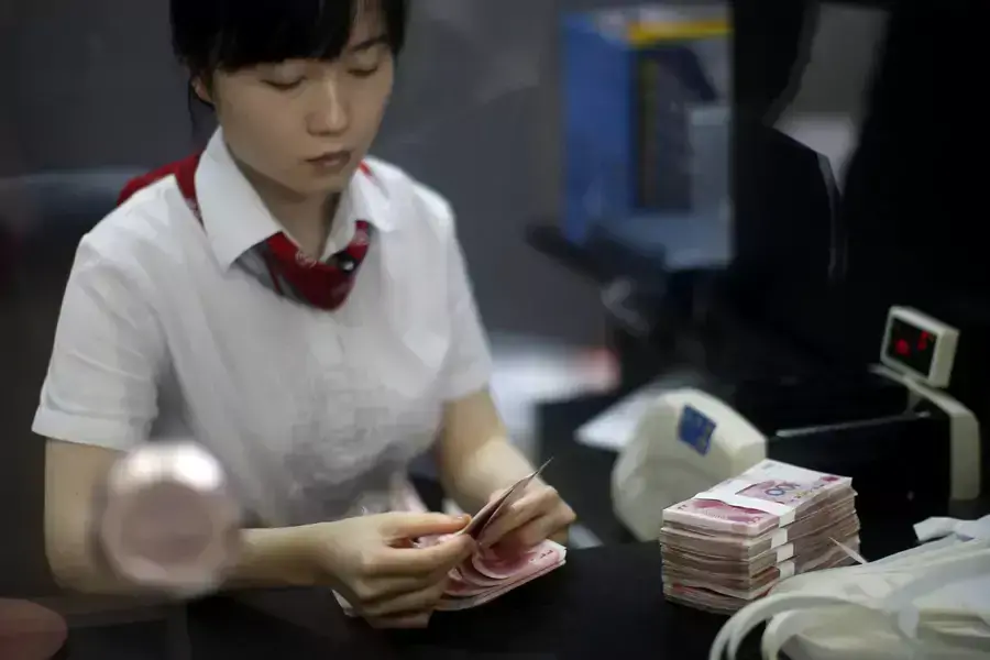 An employee at the Industrial and Commercial Bank of China Ltd counts money at one of the bank's branches in Pudong district, September 24, 2014.