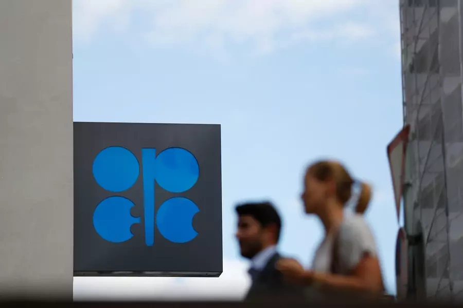 Two persons pass the logo of the Organization of the Petroleoum Exporting Countries (OPEC) in front of OPEC's headquarters in Vienna, Austria June 19, 2018. 