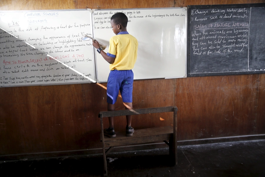 A student stands on a bench to write on the board at a floating school in the Makoko fishing community on the Lagos Lagoon, Nigeria February 29, 2016. In Makoko is a sprawling slum of Nigeria's megacity Lagos, and the school provides free educatio.