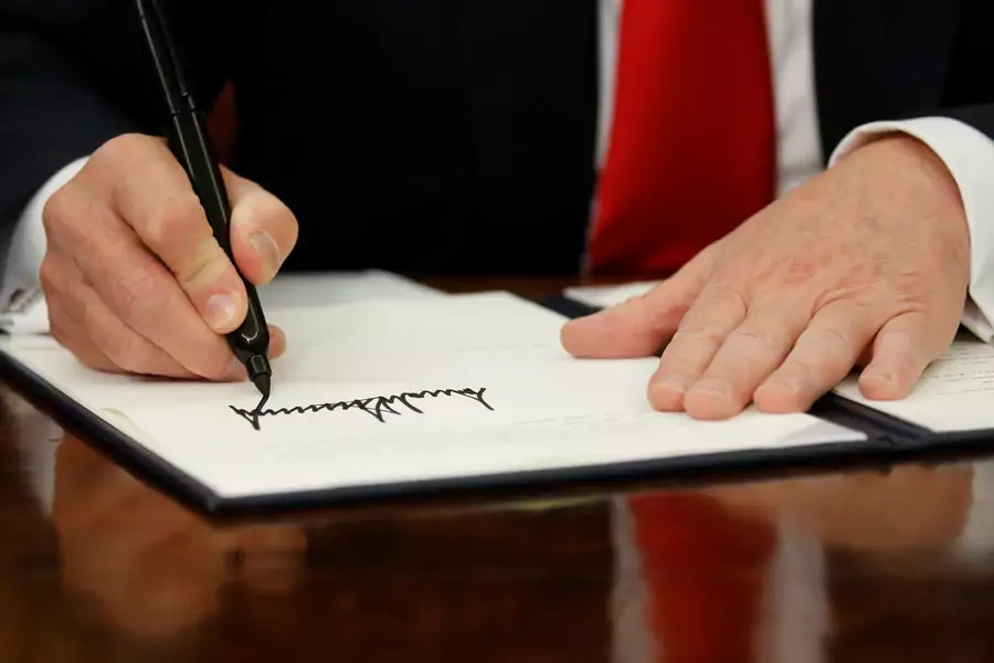 U.S. President Donald Trump signs an executive order on immigration policy in the Oval Office of the White House in Washington, U.S., June 20, 2018.