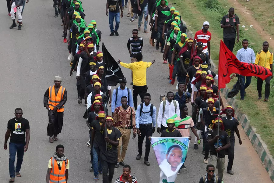 Members of Islamic Movement of Nigeria (IMN) wave flags and chant slogans as they take part in a demonstration to protest against an imprisoned Shiite cleric, in Abuja, on October 29, 2018.
