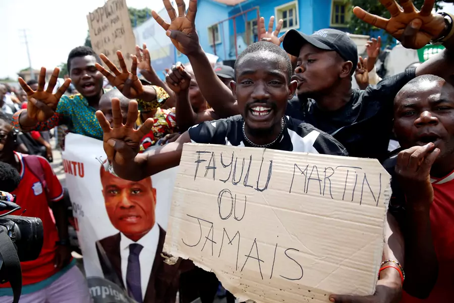Supporters of the runner-up in Democratic Republic of Congo's presidential election, Martin Fayulu hold a sign before a political rally in Kinshasa, Democratic Republic of Congo, January 11, 2019. 