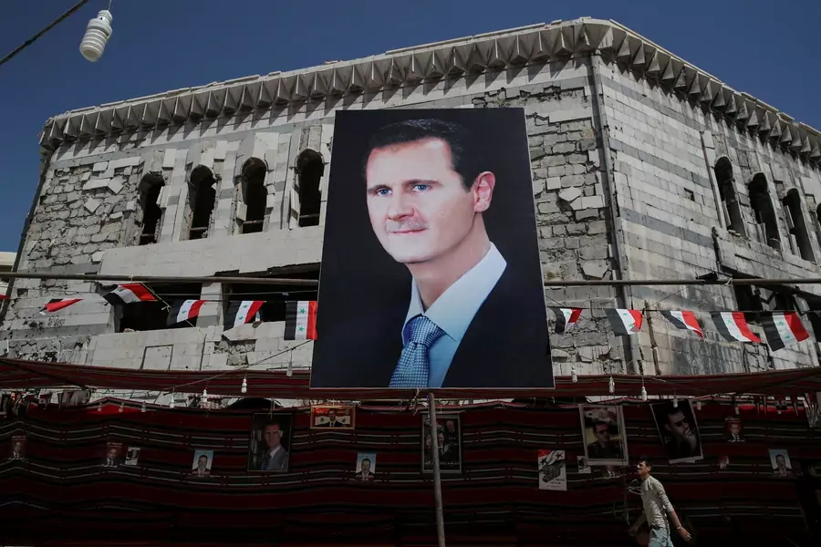 A man walks past a banner depicting Syrian President Bashar al-Assad in Douma, outside Damascus, Syria, on September 17, 2018. 