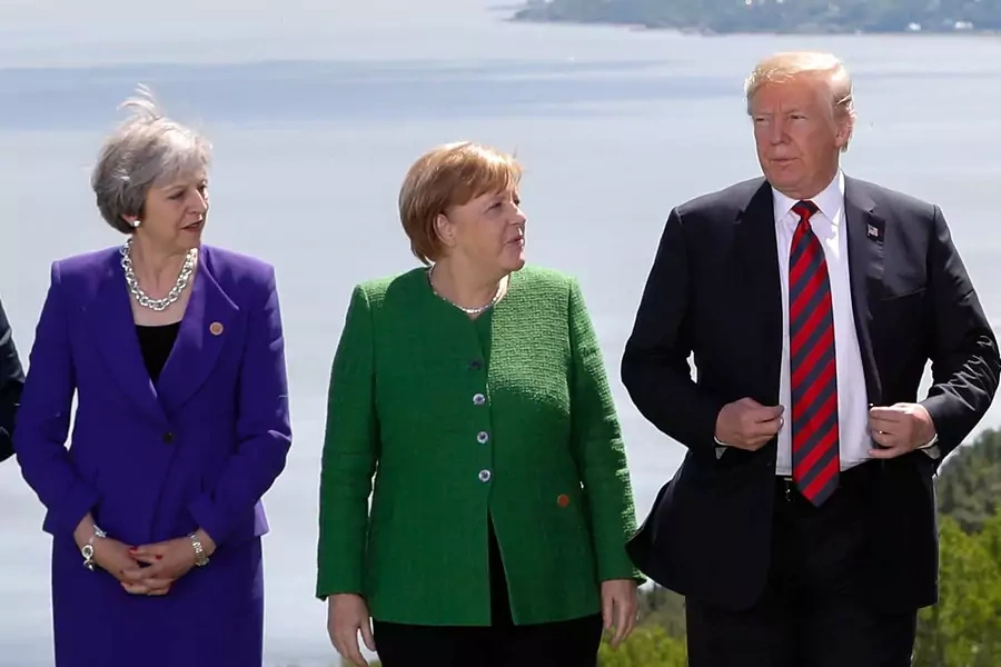 British Prime Minister Theresa May, German Chancellor Angela Merkel, and U.S. President Donald J. Trump pose during a family photo at the G7 Summit in the Charlevoix city of La Malbaie, Quebec, Canada, June 8, 2018.